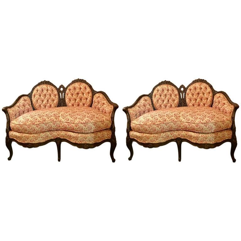 Pair of Louis XV Style Carved Settees or Loveseats: A fine pair Of Louis XV style carved settees or loveseats. Custom quality pair of finely carved walnut frames with flowing roses and leaf with vine design. These double cameo back settees have kidney