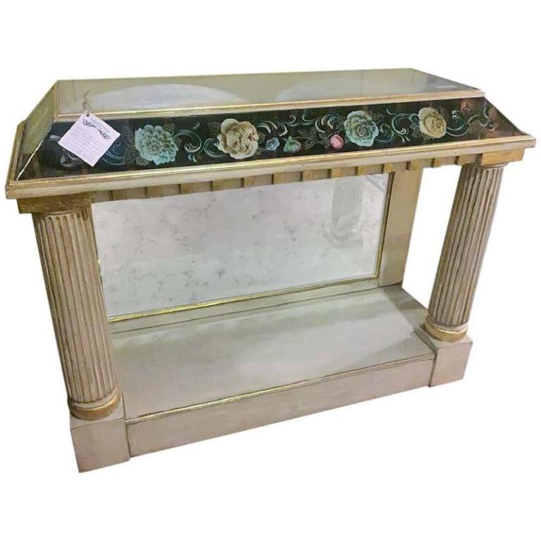 Eglomise Pier Table: Distressed glass top and sides. Glass sides decorated With floral motif. Floor level base with secondary shelf, distressed mirrored back and gold detail over a white painted base coat. White painted s