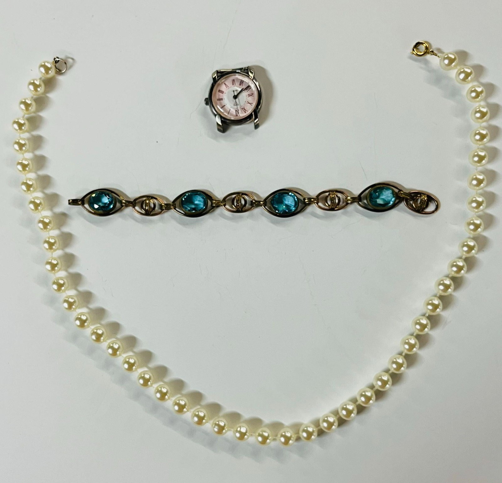 A Bracelet, a Necklace and a Watch: A pearl necklace 18 inches. A bracelet with 4 semi precious gem, 6.5 inches. A Guess brand watch.