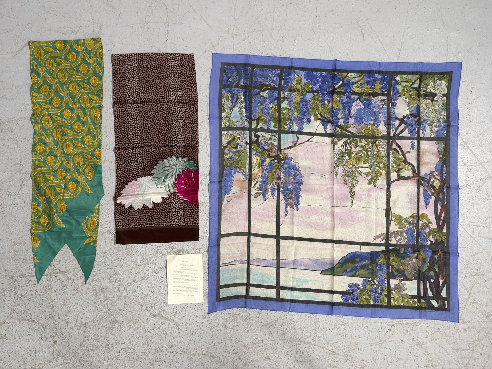 Three Silk Scarves, incl One "View of Oyster Bay": Three Silk Scarves. One with Metropolitan Museum store tag, the Tiffany Studio "View of Oyster Bay" scarf with blue borders, measures 34 x 34 inches.