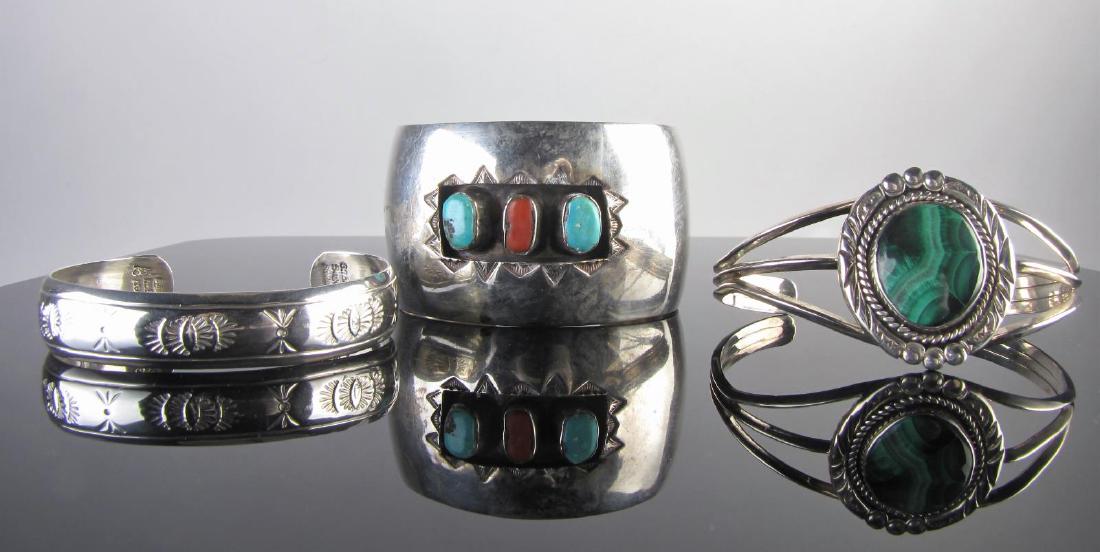 Three Southwest Sterling Cuffs, G. Begay, Edsitty: Three southwest sterling silver cuffs including a Gilbert Begay, etched cuff, marked, 13.4g; a Nita Edsitty, marked sterling, Navajo cuff with malachite stone, 26g; and an unmarked (tested .925) wide
