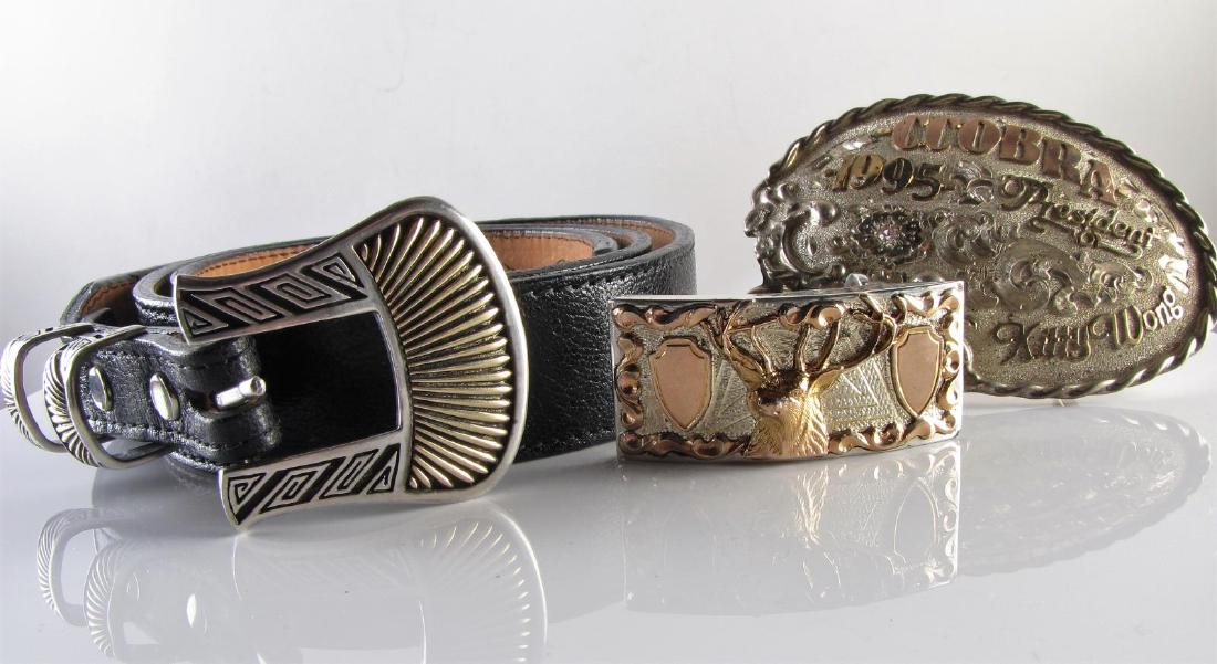 Belt and Belt Buckles: A size 44, genuine kidskin, black leather handmade belt by Circle of Yonken, from City Electric Shoe Shop, with Teme sterling silver buckle (rolled), 901899; a Sterling silver belt buckle marked F28 (