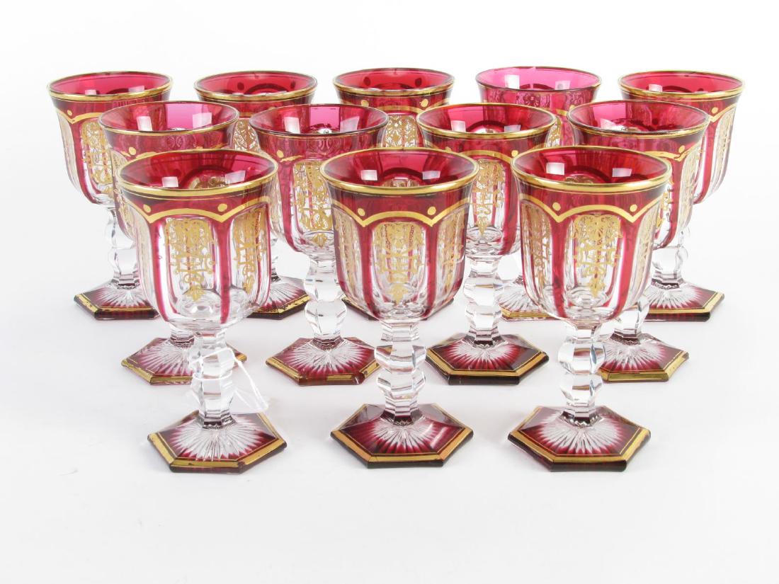 Set of Twelve Moser StyleRuby Cut To Clear Wine Glasses: Set of Twelve Ruby Cut To Clear Moser-style wine glasses, desert wine glasses having hexagonal bases, clear faceted stems, ruby cut-to-clear cups with gold shield decoration, 5" high; CONDITION: 3 or 