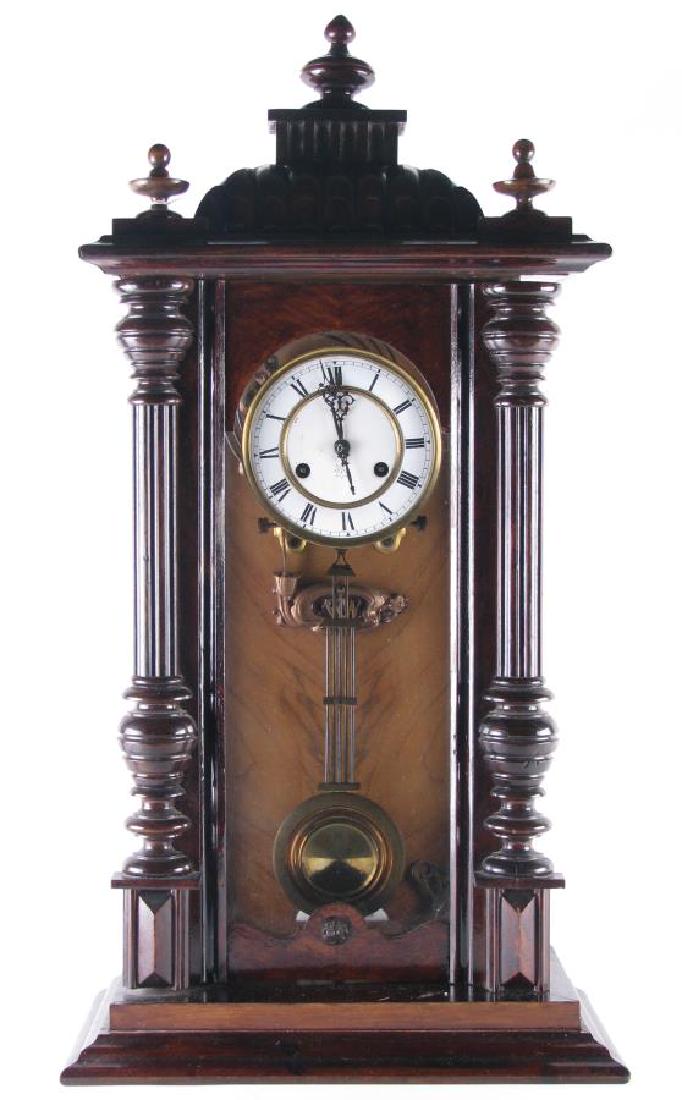 Junghans German Shelf Clock: Junghans German Shelf Clock, wood carved case with half fluted columns, porcelain clock face with roman numerals, key and pendulum included, three removable finials, 15.5" x 8.5" x 31" high