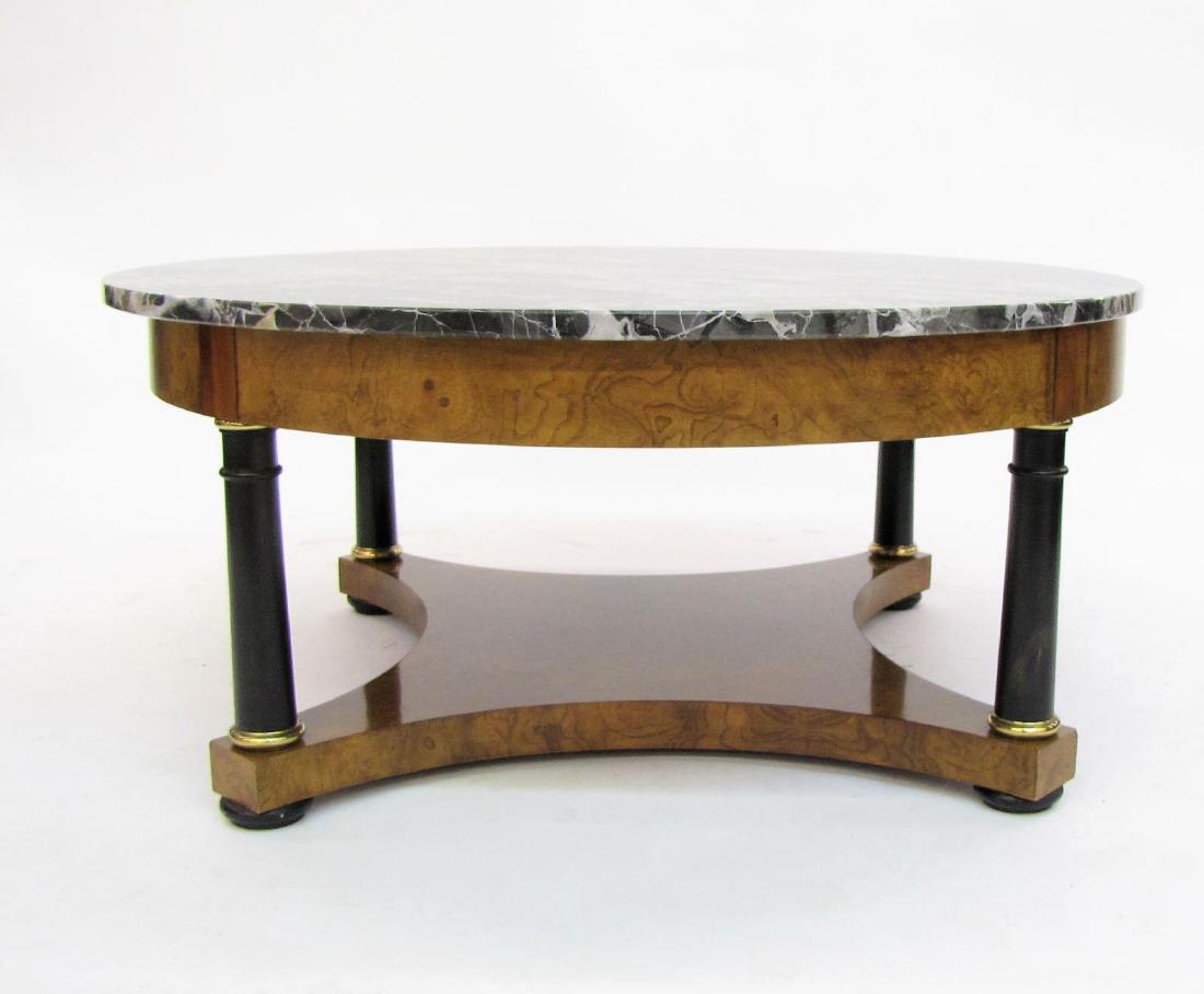 Baker Furniture Marble Top Cocktail Table: A Baker Furniture, marble top cocktail table, neo-classical style with ebonized posts and brass trim, black marble top with white and gold veining, 38" diameter, 17" high