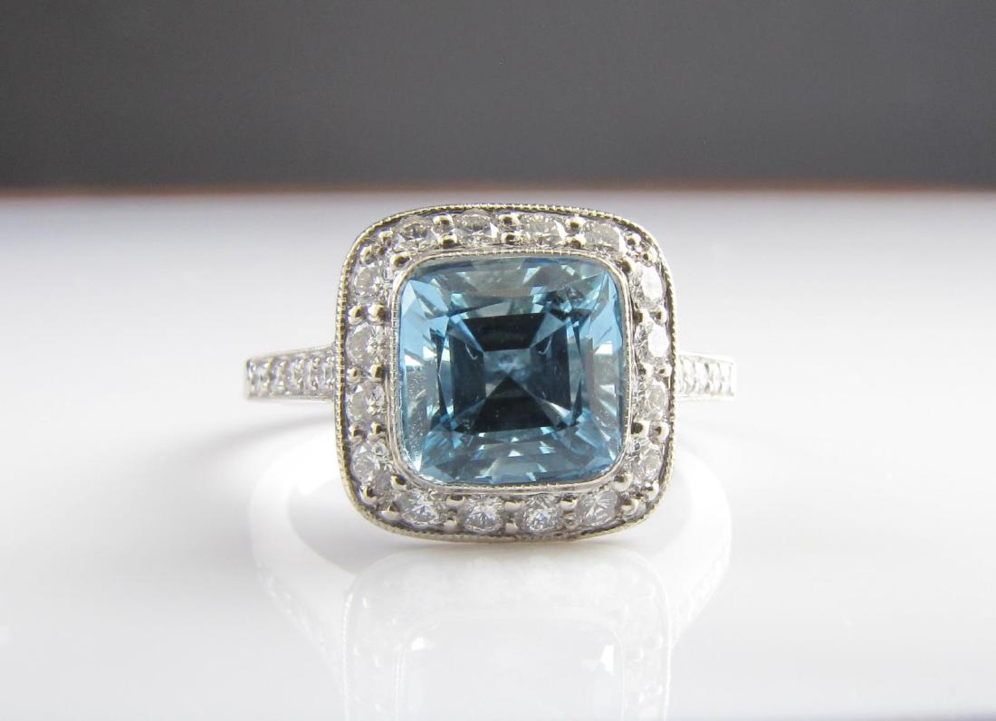 Tiffany & Co. Platinum Aquamarine, Diamond Ring: A Tiffany & Co. platinum ring from the Legacy Collection featuring a cushion shaped, approximately 1.20ct, aquamarine, surrounded by sixteen round brilliant cut diamonds and twenty-six round brilliant