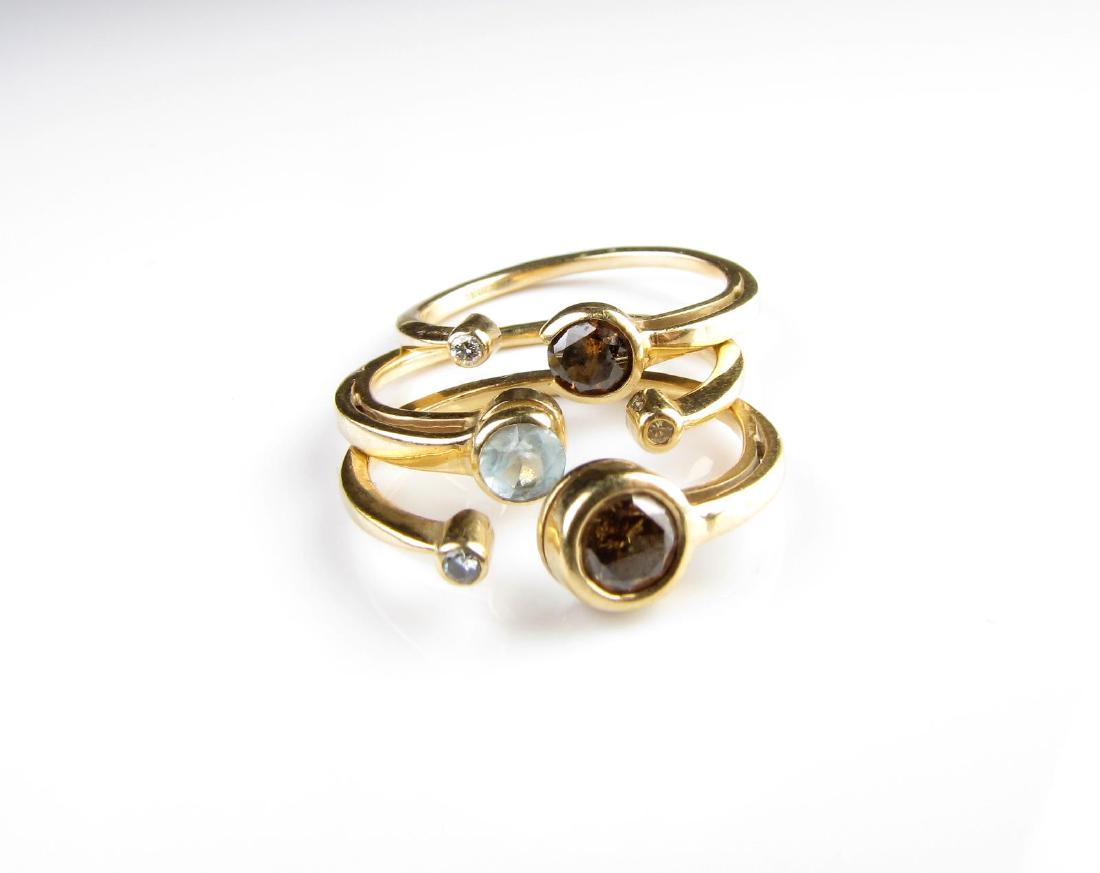 Three Gold Rings, Diamond, Aqua, Choc. Diamond: Three stackable open design rings including aquamarine and diamond ring stamped 14K and illegibly inscribed with maker's mark; a chocolate diamond and white diamond illegibly inscribed with maker's ma
