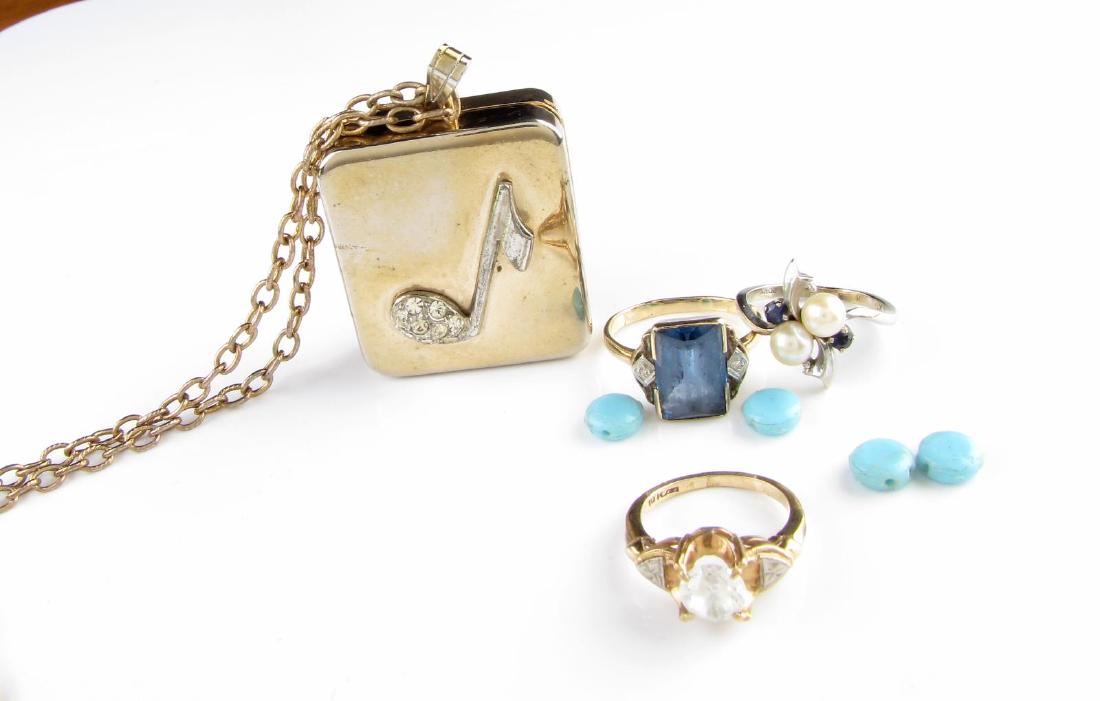10K and Reuge Jewelry: Three 10K Gold rings one with pearl and blue stones, one with blue topaz colored stone and two side diamonds, and one with approximately synthetic clear stone; also includes a Reuge Ste Croix miniatur