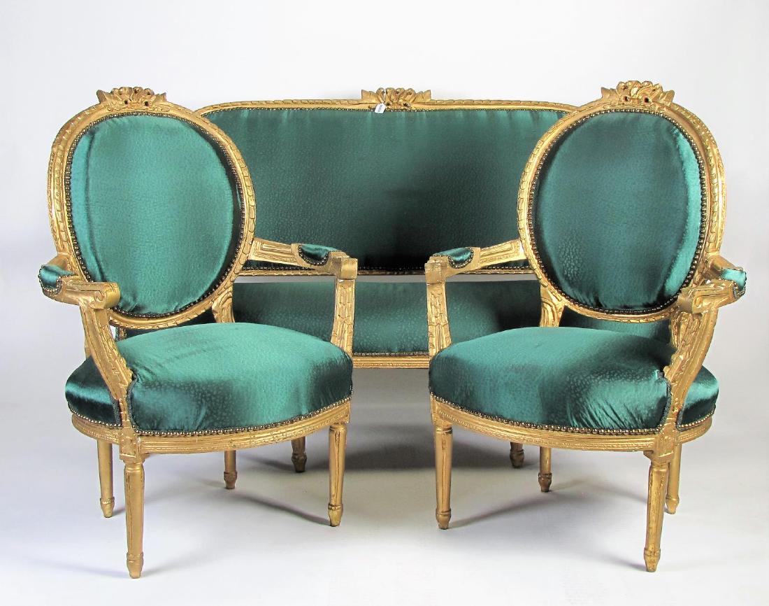 Louis XVI Style Parlour Suite: A French, Louis XVI style parlor suite, including settee and two open arm chairs, silk blend upholstery, carved and gesso frames with gold leaf, nailhead trim, ca late 19th century, sofa length 66.5" 