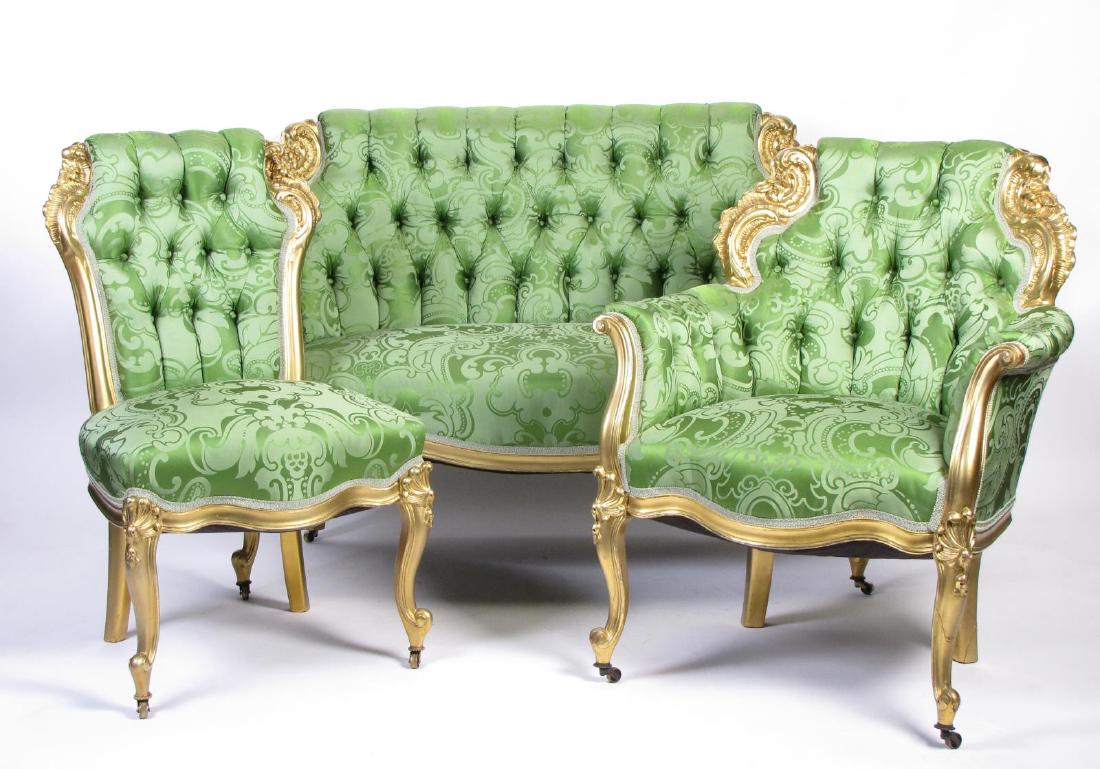 Three Piece French Parlour Suite: A three-piece French parlour suite, including settee, and gent's and lady's chair, gold leaf carved frames, button-tufted damask tone-on-tone upholstery, caster wheels on all three pieces, settee leng