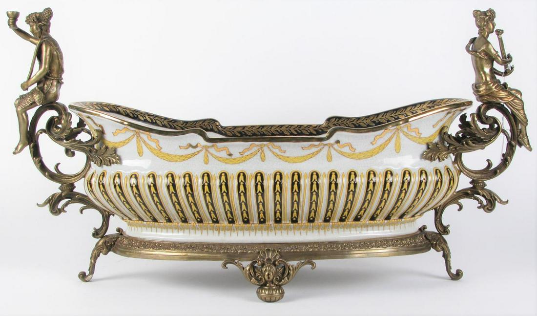 Mark Roberts Porcelain and Bronze Mounted Bowl: A Mark Roberts oval porcelain centerpiece bowl with craquelure finish, floral decorated interior, black and yellow enameled exterior, bronze figural mounted handles depicting woman with harp and man h