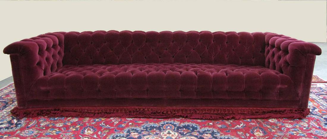 Burgundy Chesterfield Style Sofa: A Chesterfield style sofa, with button and tufted burgundy cloth upholstery, with fringe skirt (does not have legs), 102"l, seat height 12", overall height 24"
