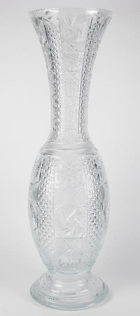Signed Monumental Cut Glass Floor Vase: A monumental beautiful cut glass floor vase with starburst and diamond decoration, round base, flared rim, on wood carved base, artist signed illegibly top rim, 36.75" high
