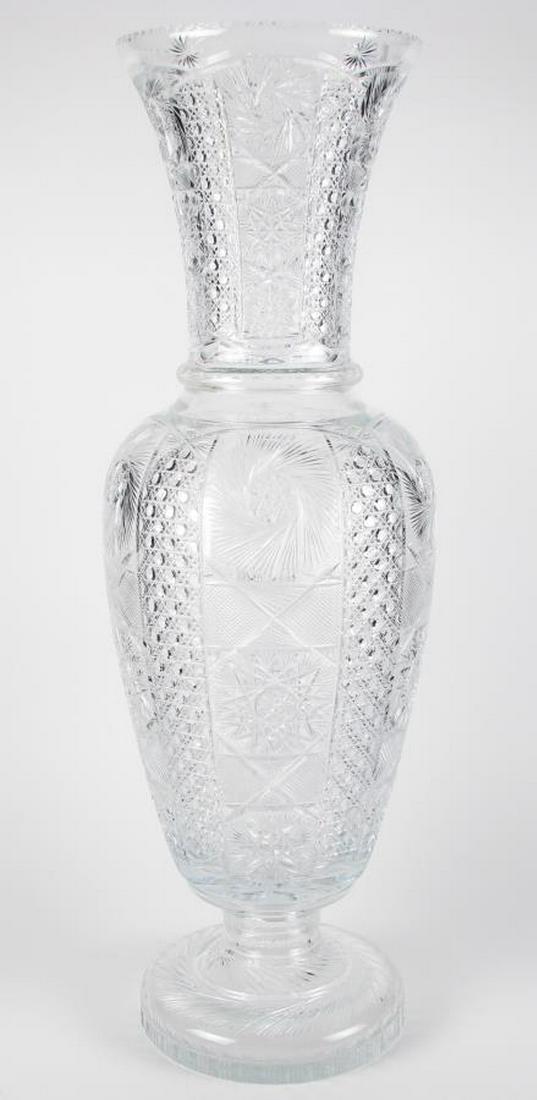 Signed Monumental Cut Glass Floor Vase: A monumental beautiful cut glass floor vase with starburst and diamond decoration, round base, flared rim, on wood carved base, artist signed illegibly top rim, 34" high