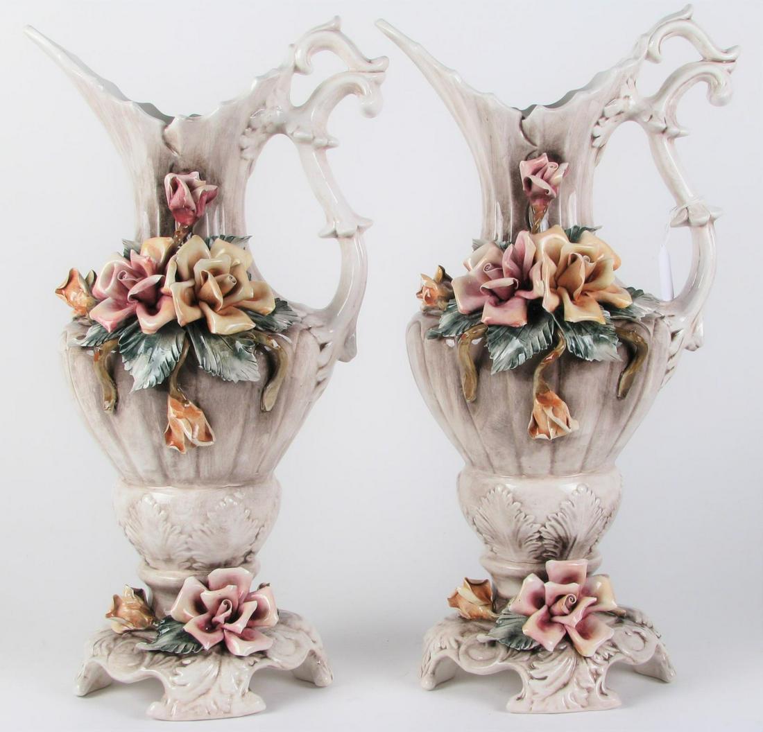 Pair of Capodimonte Ewers: A pair of Capodimonte porcelain ewers, white and gray wash glazed ewers with yellow and pink rose decoration, footed base, hallmarked on underside "Capo Made in Italy" with Capodimonte hallmark, 20.25