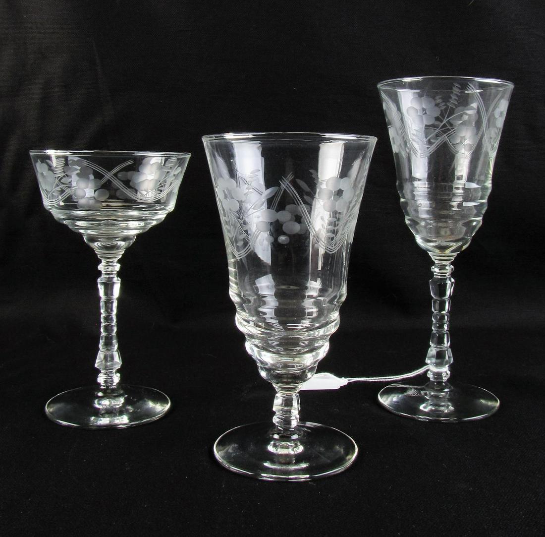 Three Sets of Etched Crystal Stemware: Three sets of etched crystal stemware, twenty-two total including ten wine glasses, five iced tea glasses and seven champagne/tall sherbet glasses, all with etched floral decoration, 6" - 8" high