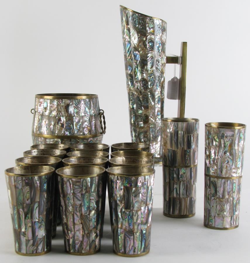 Vintage Taxco Brass and Abalone Cocktail Set: A vintage Taxco brass and abalone cocktail set includes twelve cups, a pitcher, an ice bucket (one ring handle missing), and two highball cups; 4.5" to 11" high