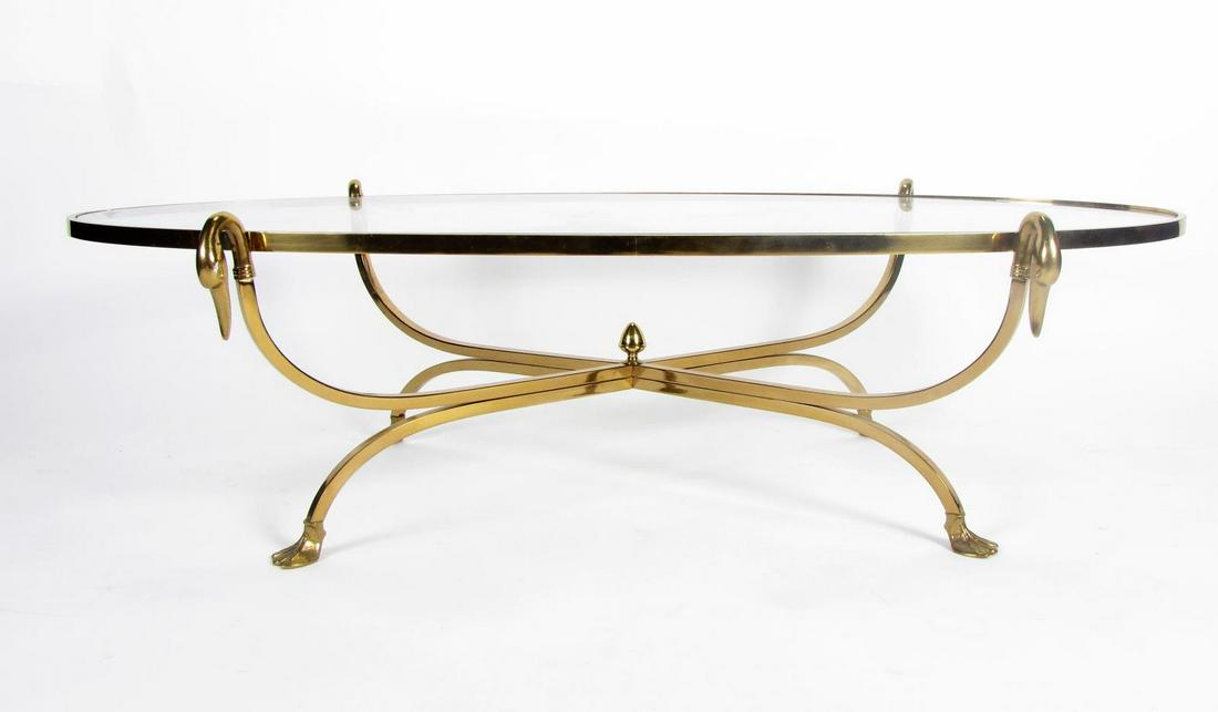 Glass top Cocktail Table: Neoclassical style cocktail table, with brass frame having bird head motif, and glass top, 52 x 24 x 14