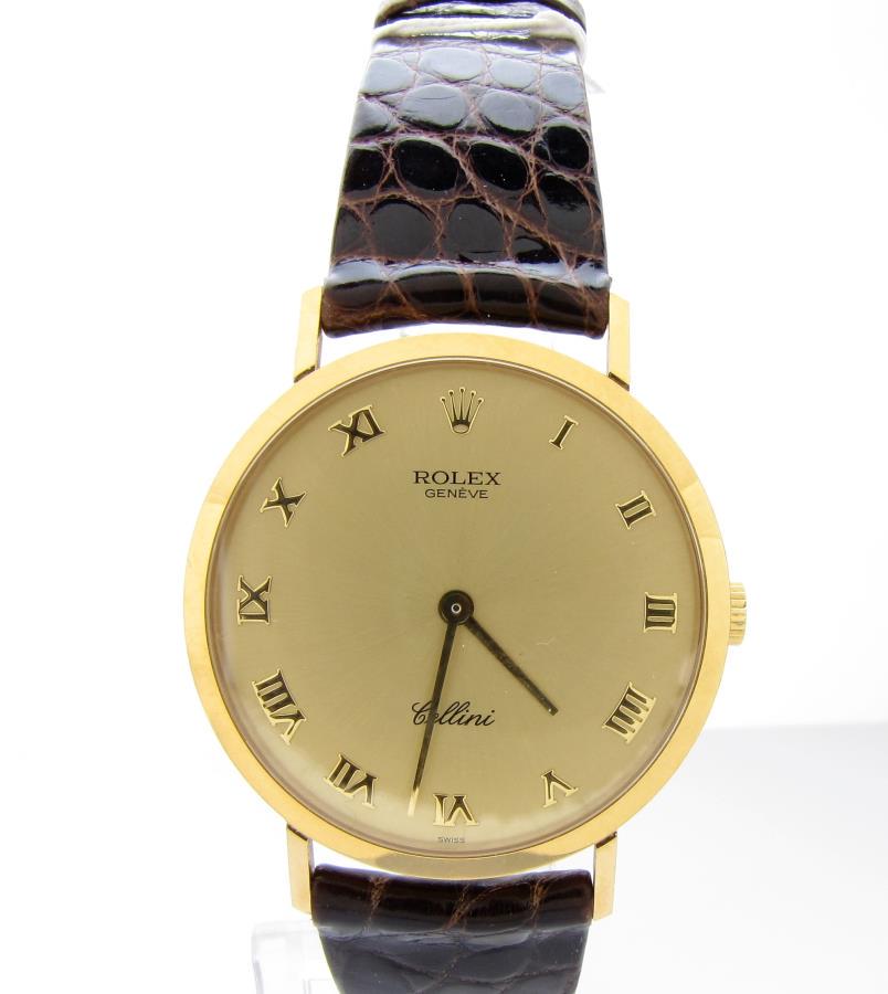 Gents 18K Yellow Gold Rolex Cellini Watch: A gentleman's 18K yellow gold Rolex Cellini Mechanical 4112 wristwatch with gold dial accented with Roman numeral markers, and completed with a brown, genuine crocodile strap with gold Rolex buckle; b