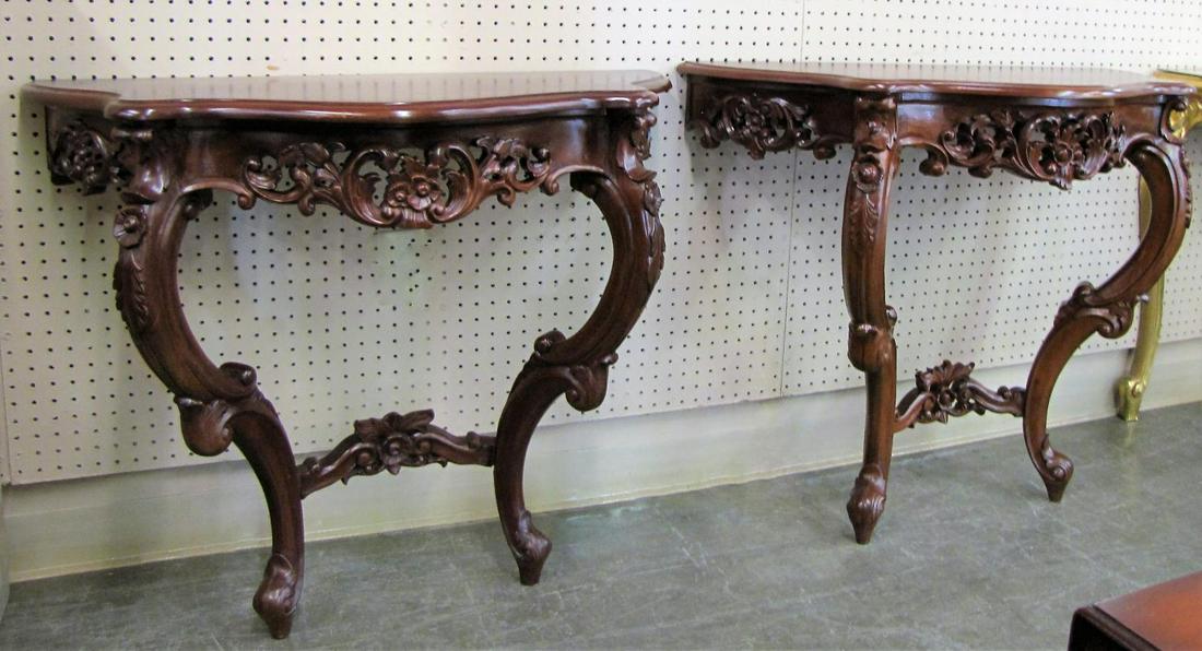 Pair of Carved Mahogany Wall Consoles: A pair of carved mahogany wall consoles, reticulated carving with floral motif, two legs each, late 20th century (slight difference in size/finish), 34x18x30"h