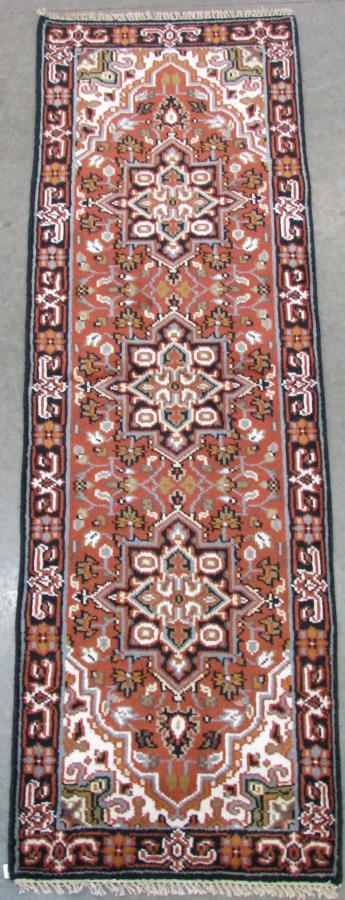 Handmade Heriz Runner Rug: Handmade Heriz Runner Rug, having a rust field with blue, black and tan repeating medallions, blue, green and tan floral decorated field, black border with red and tan floral decoration, 8'2" x 2'7"