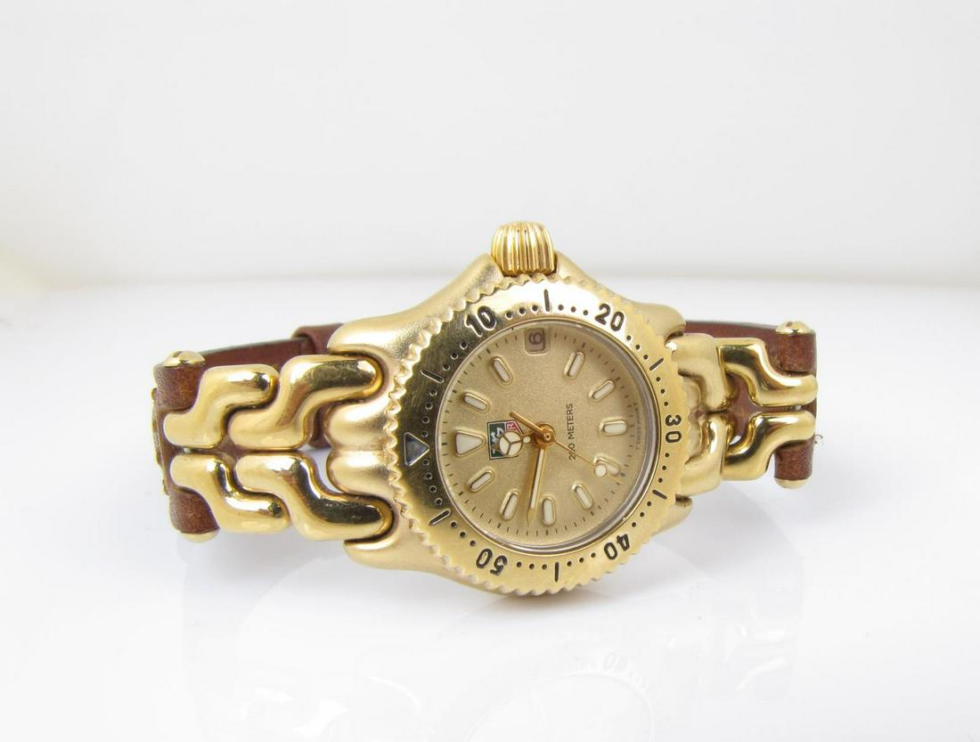 Lady's Tag Heuer 200m Wristwatch: A lady's S94.408C Tag Heuer 200m wristwatch, gold plate and stainless steel, gold fleck dial, luminescent ivory markers, luminescent hands, second hand, rotating bezel on adapted chain and leather str