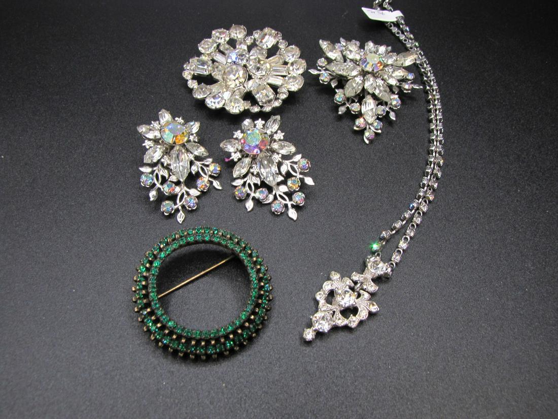 Group of Signed, Vintage Costume Jewelry: A group of signed, vintage costume jewelry, including Warner 1.75" circle pin with green rhinestones, a Bogoff pendant on 14" chain, a starburst pin, 2.25" diameter, signed 'by Gale', and a three-piec