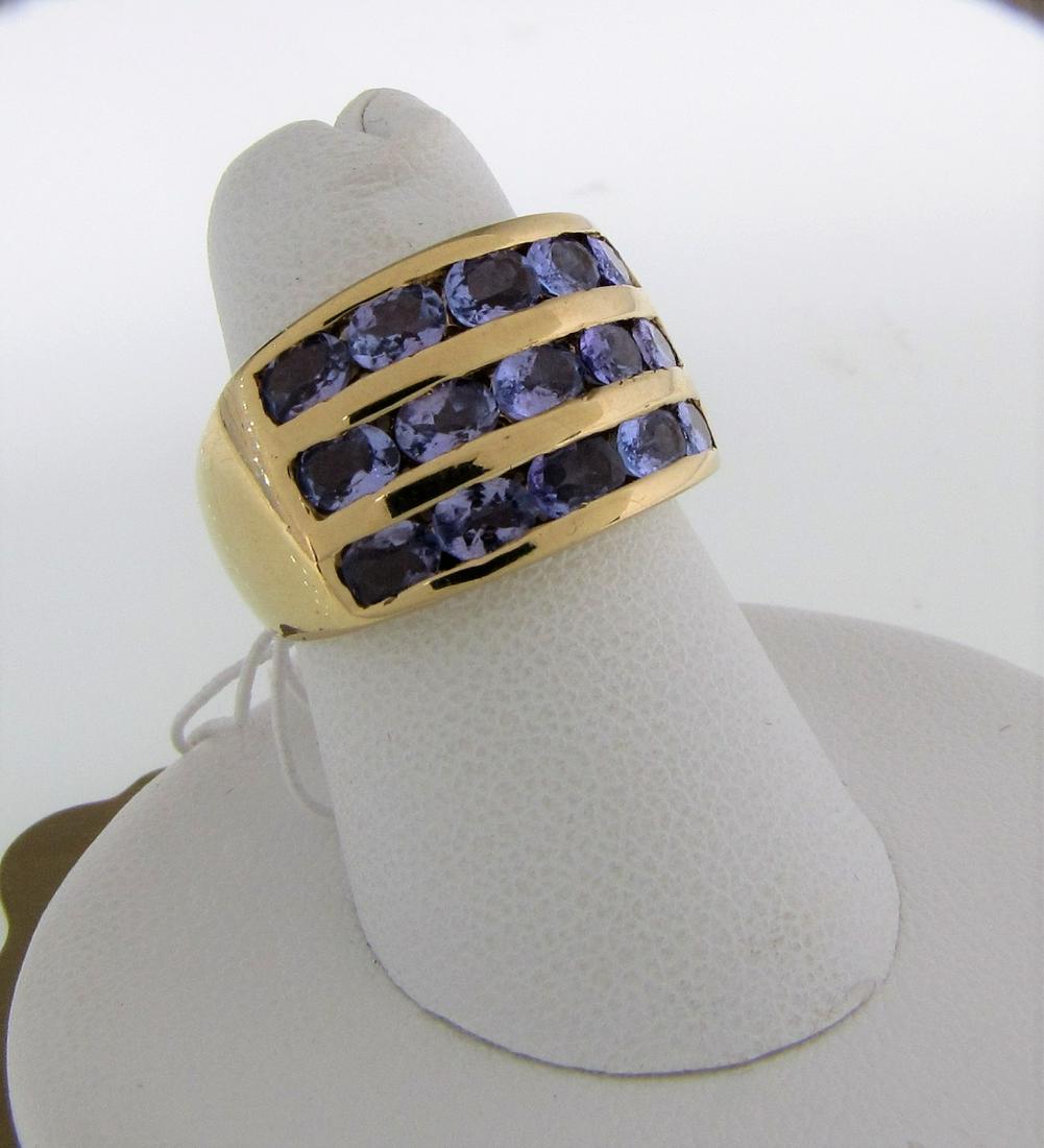 14K Yellow Gold Tanzanite Ring: A 14K yellow gold wide band ring, graduated in width from 12.5mm to 3.5mm, featuring three rows of five oval channel set tanzanite, each approximately 4mm x 2mm x 1.6mm, size 6, 3.5dwt ring weight