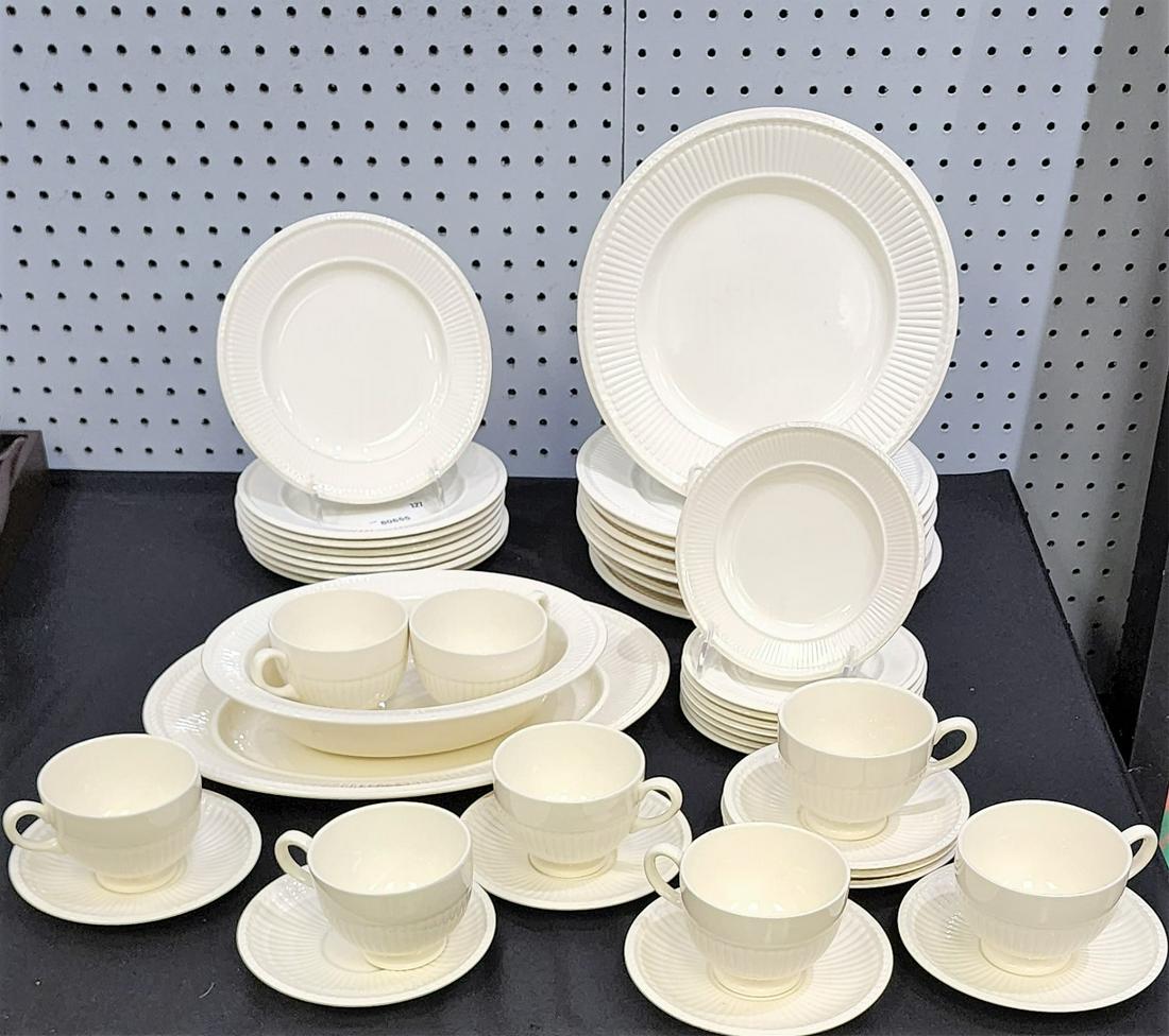 Set of Wedgwood "Edme" Porcelain Dinnerware: A set of Wedgwood dinnerware, Edme pattern, service for 8, dinner plates, salad plates, bread plates, cups and saucers, oval vegetable bowl, oval meat platter. One saucer with larger chip focused on b