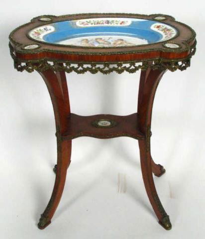 Louis XV Table with Porcelain Inserts: Louis XV style table, with bronzed ormolu mounts in floral garland motif, hand-painted porcelain platter and medallions depicting cupids and flowers, platter measures 20x14 oval, table is 29 inches hi