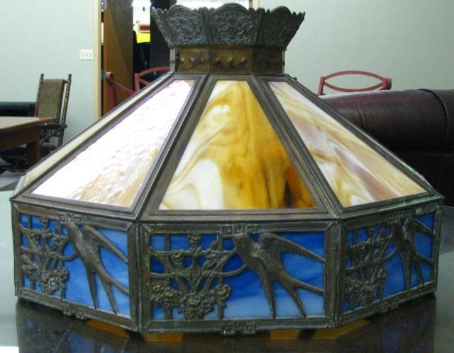 Antique Slag Glass Hanging Light: Antique hanging, lamp, 9-panel glass, reticulated bird and floral motif, carmel and blue glass, cast metal frame