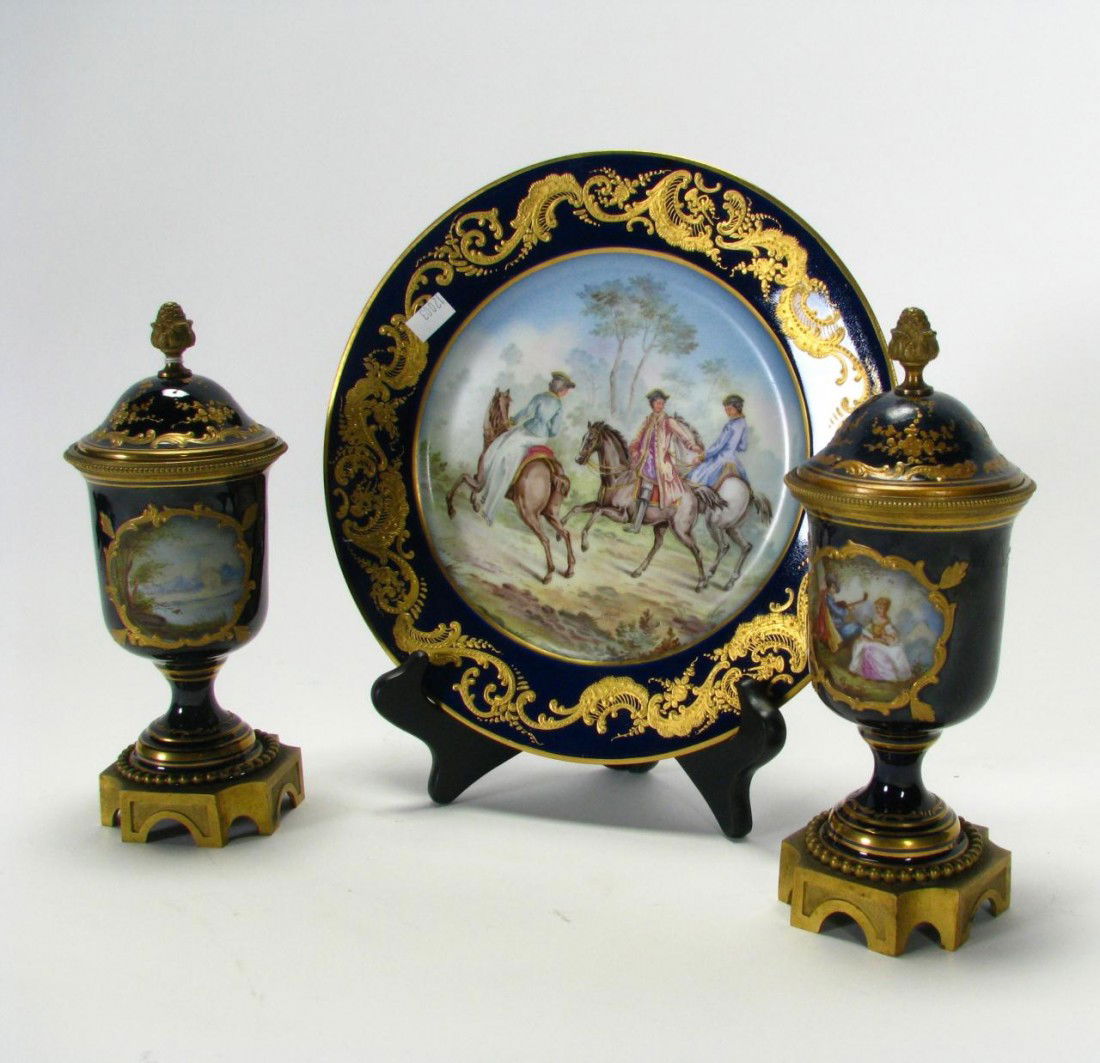 Group of Sevres, Dresden Style Decorator Porcelain: Group of Sevres Style Decorator Porcelain including set of twelve cobalt and gold enameled plates with classic scenes, 9.5" diameter, and a pair of cobalt lidded cabinet vases with a Dresden type mark