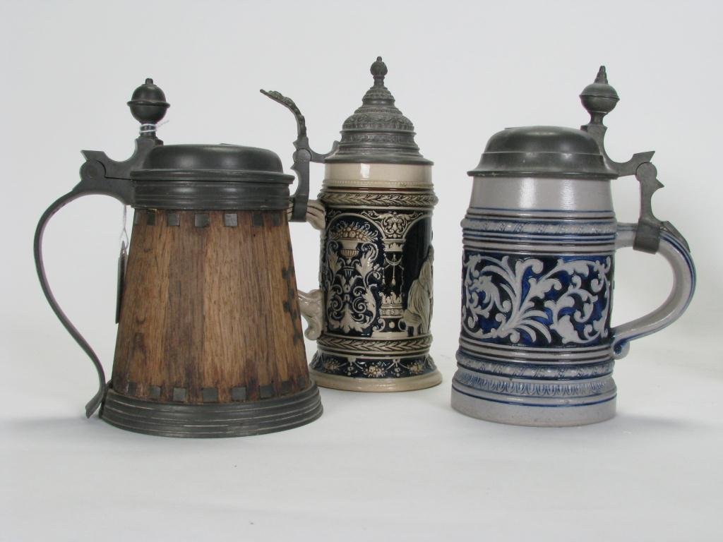 Group of Three Lidded German Drinking Vessels: Group of Three German Drinking Vessels including wooden Half Liter Daubenkrug (French made), inscribed "Zum Wohl"; a Half Liter blue and white; and a 3/10 Liter with cabin scene