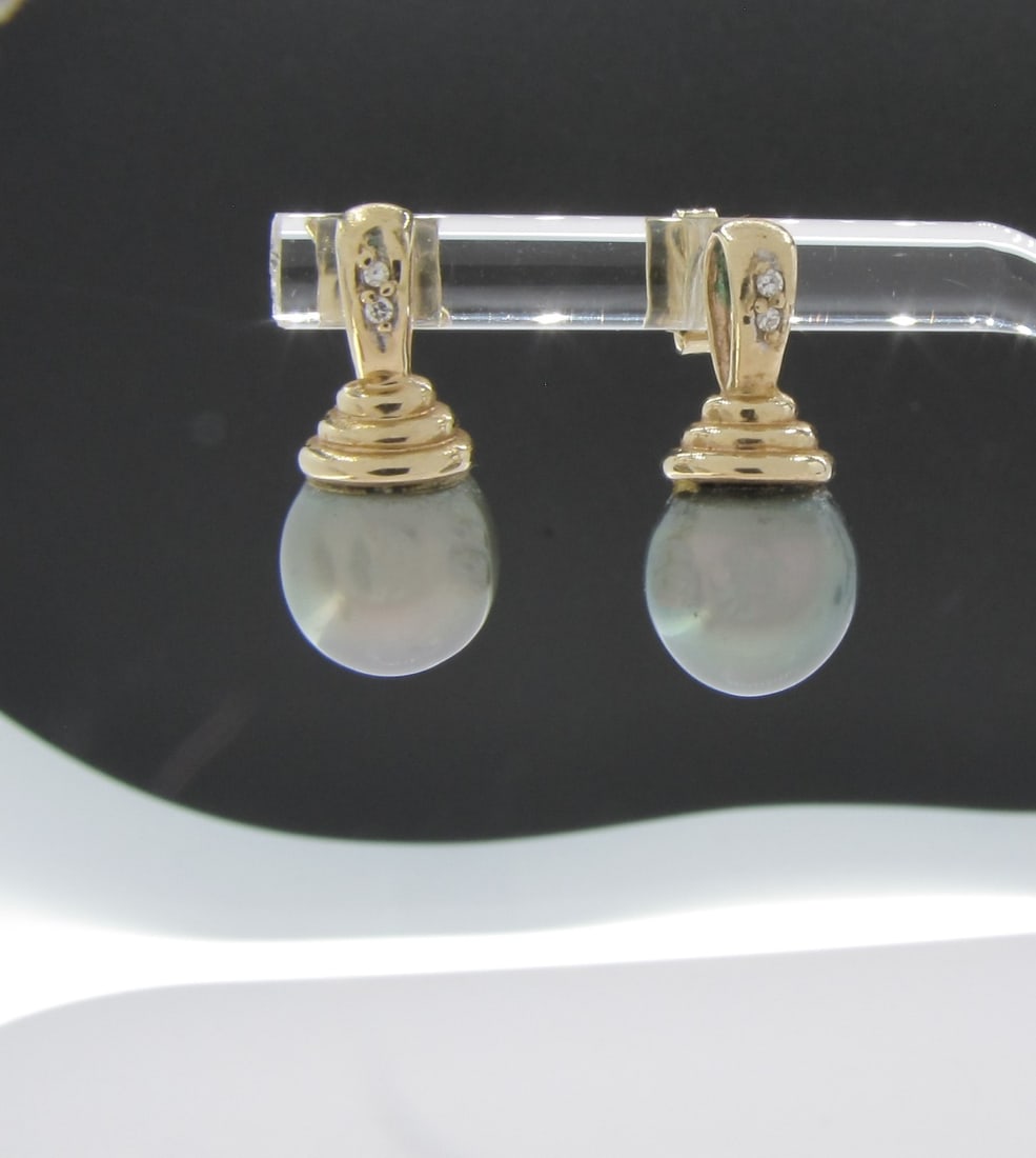 Pair 14K Yellow Gold Black Pearl, Diamond Earrings: A pair of 14K yellow gold earrings featuring 9mm black pearl drop with four diamonds weighing approximately .05ctw. Earrings are approximately .75" long. Retail $1,400