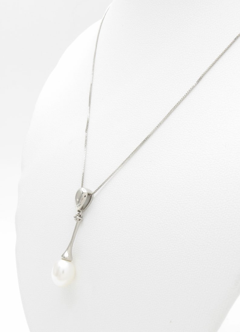 14K White Gold Pearl, Diamond Pendant: A 14K white gold white cultured pearl drop pendant with approximately 11mm x 8mm oval pearl and .15ctw prong set round white diamond, on a delicate .60mm, 18.5" long box chain.