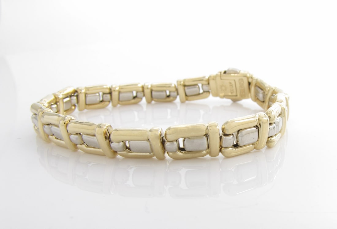 18K Two-Tone Chimento Link Bracelet: An 18K yellow and white gold link bracelet by Chimento, with plug in/push button clasp, 7.25" long. Bracelet weight 13dwt. Retail over $3,000.
