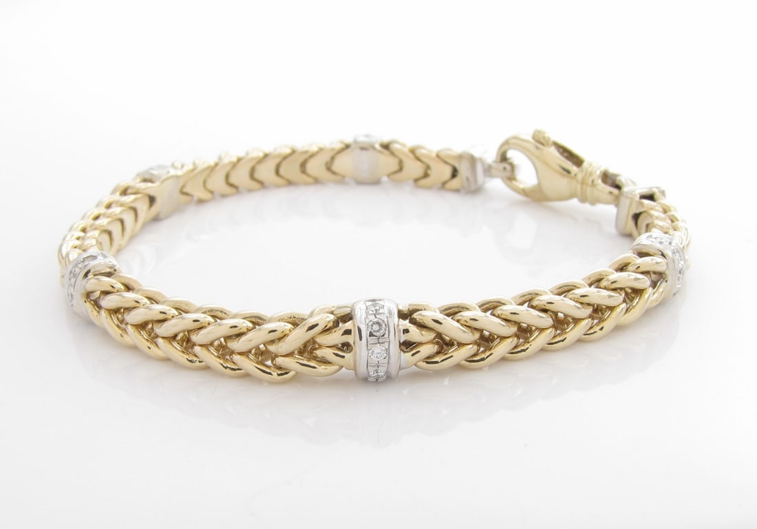 14K WG/YG Diamond Station Wheat Chain Bracelet: A 14K white and yellow gold heavy square wheat chain bracelet with five rondelle stations, each containing five round brilliant cut diamonds. Total diamond weight .25ctw. Bracelet weight 18dwt. Retail
