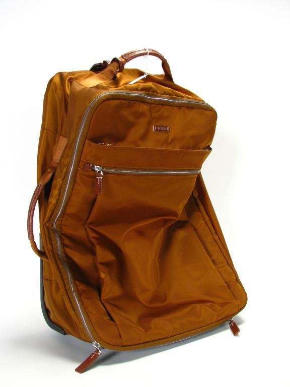 Tumi Voyageur Super Leger International Carry-On: Tumi Voyageur Super Leger International carry-on. Copper with sky blue interior, telescopic handle, smooth roll wheels, multiple compartments. Model 48600RS, 21 1/2" x 15" x 8". Retail $395