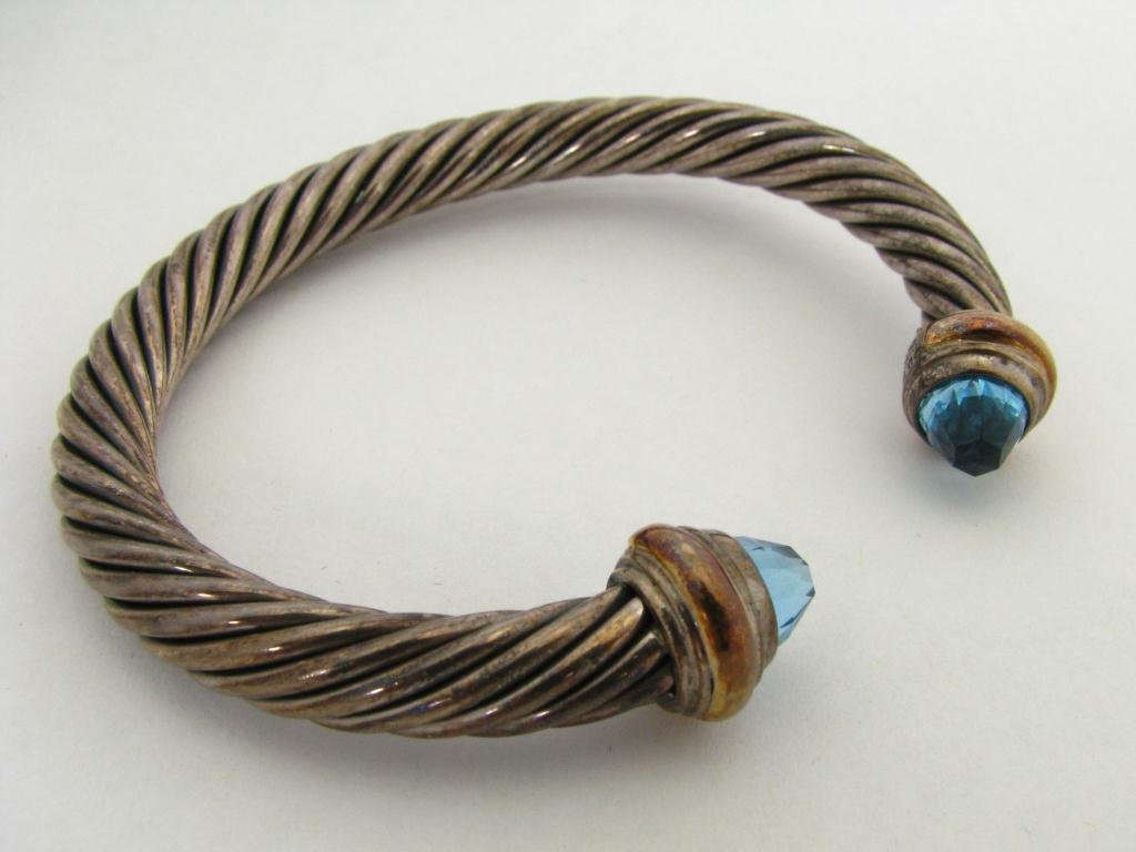David Yurman Blue Topaz "Color Class" Collection S: David Yurman blue topaz "Color Class" collection 5 mm cable bangle bracelet. The bracelet is sterling with 14K yellow gold ends set with faceted blue topaz. Each end hallmarked DY 925 585
