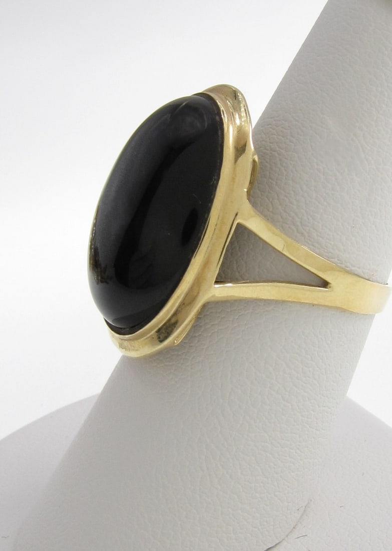 14K Yellow Gold Onyx Fashion Ring: A 14K yellow Gold fashion ring featuring a 20mm x 15mm oval, bezel set onyx in 1" mounting. Size 7.25. Ring weight 3.1dwt. Retail $700