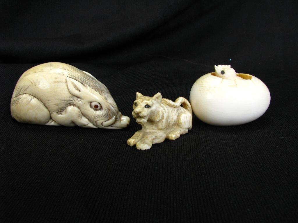 Three Japanese Carved Netsuke: Three Japanese Carved Netsuke including 2.5" warthog; a chick in egg, signed; and a signed tiger