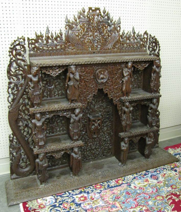 Ornately Carved Mahogany Hindu Altar: An ornately carved, mahogany Hindu altar with pierce carved with floral dragon and figural depictions of various holy men, circa mid 20th century, 57" high, 65" wide, 13" deep