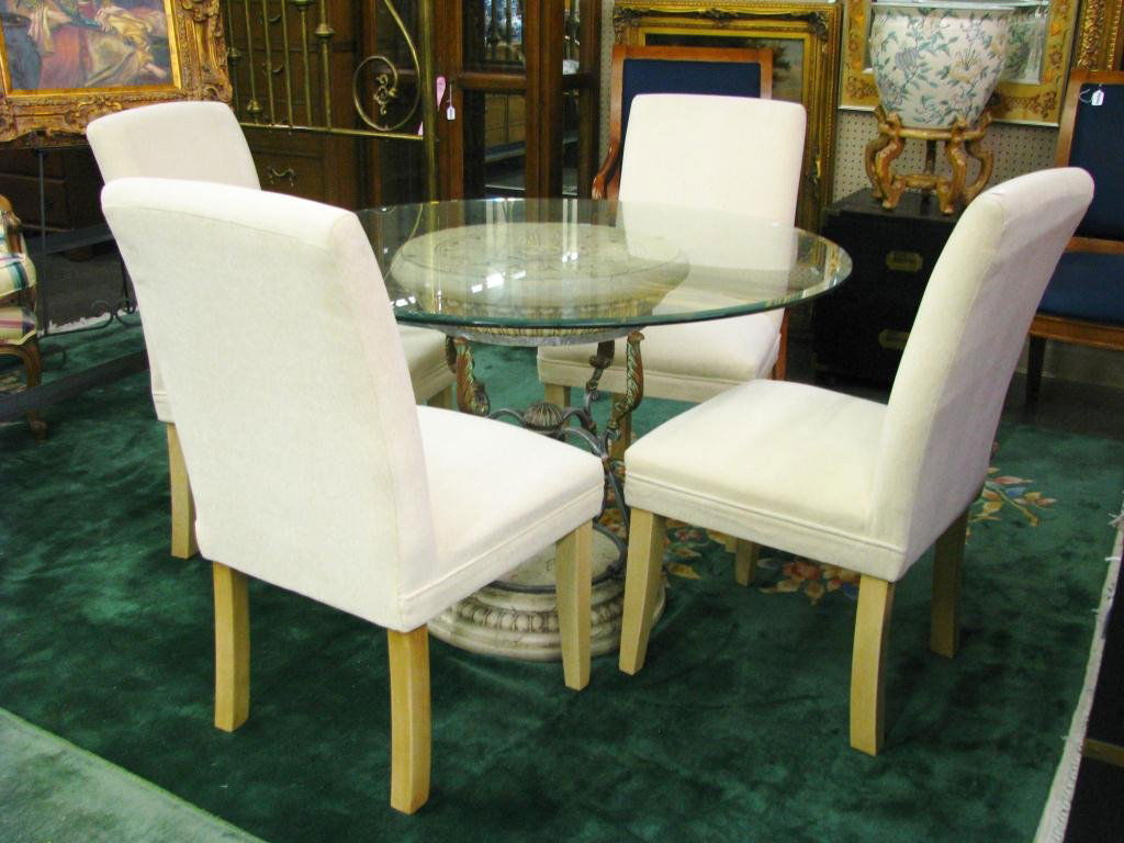 Contemporary Glass Top Table and Chairs: A contemporary glass top table and chairs, including classic style single pedestal base, with 44" beveled glass top, and four upholstered Parsons chairs.