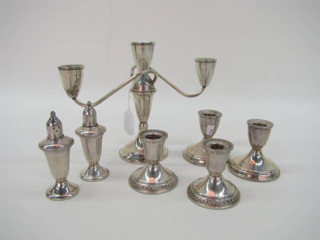 Group of Weighted Sterling Table Accessories: A group of weighted sterling table accessories, including pair of salt and pepper shakers, two pair of 3" candlesticks, and one triple candlestick