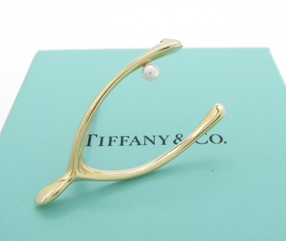 14K Yellow Gold Tiffany Pearl Wishbone Brooch: A 14K yellow gold Wishbone brooch by Tiffany & Co featuring an approximately 3.5mm cultured white pearl. Brooch measures approximately 1.75" long x .88" wide. Brooch weighs 1.8dwt.