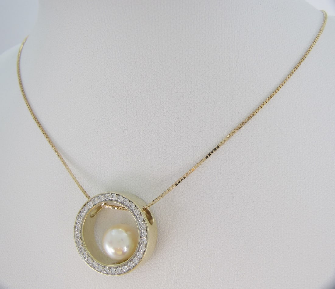 14K YG Pearl, Diamond Pendant, Chain: A 14K yellow gold .75" diameter open circle pendant with 9mm cultured pearl and approximately thirty-six round diamonds channel set, weighing approximately .50ctw. 14K yellow gold, 10" long box
