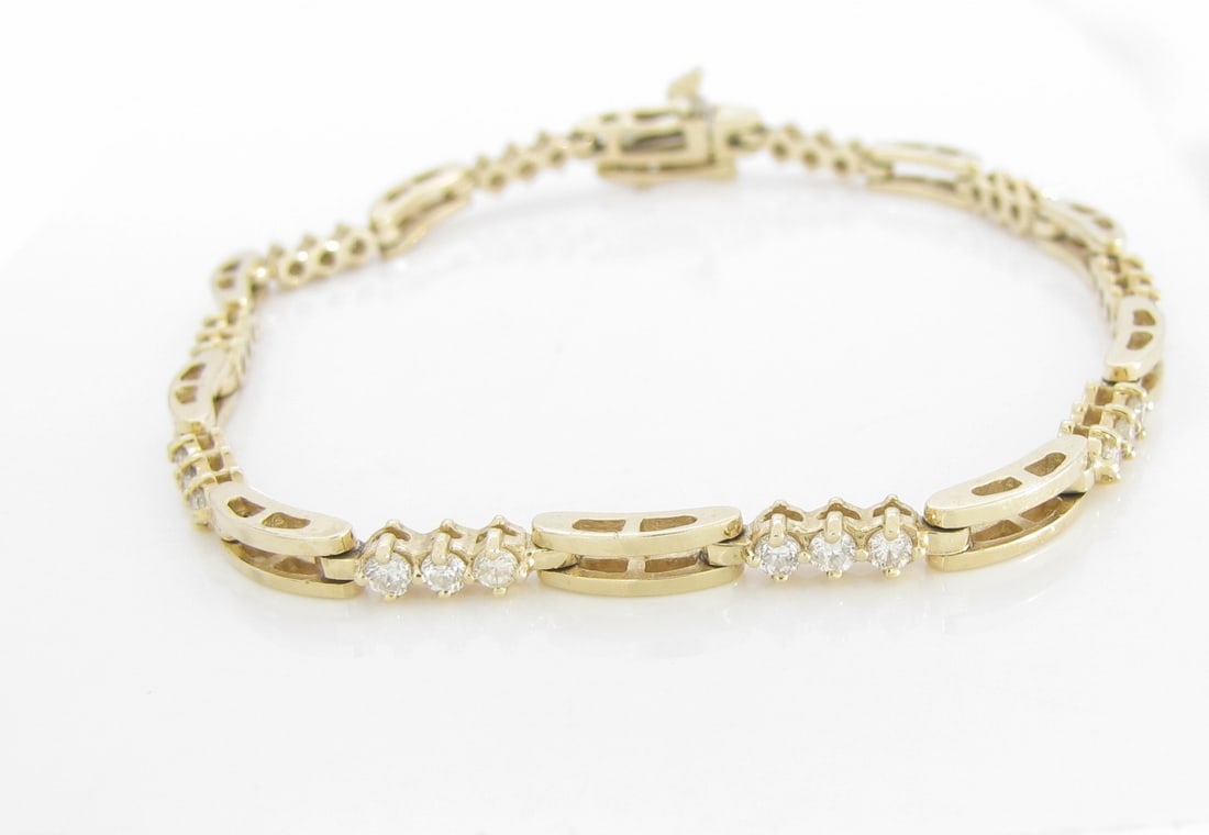 14K Yellow Gold Diamond Bar Link Bracelet: A 14K yellow gold tennis style bracelet with bar links and thirty diamonds weighing approximately .45ctw of SI clarity and H-I color. Approximately 7" long. Bracelet weighs 6.1dwt.