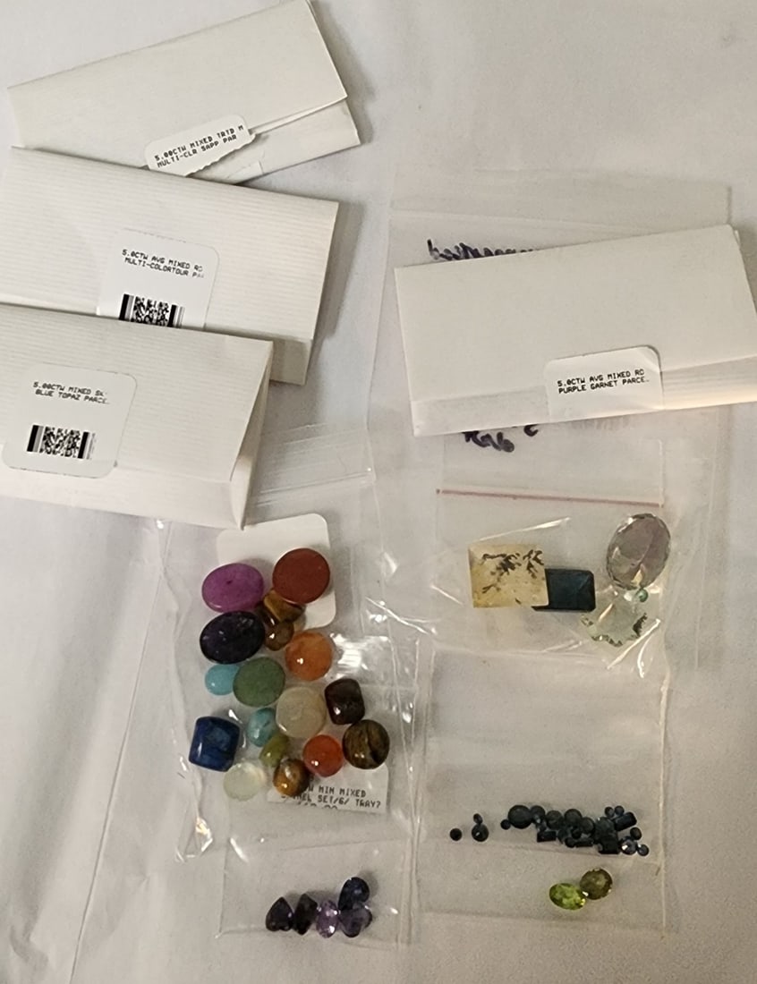 Loose Gemstones: A bag of loose gemstones including seventeen cabochon mixed small stones; two green colored gemstones; approximately twenty-two very small sapphire blue colored stones in a bag; several retail paper