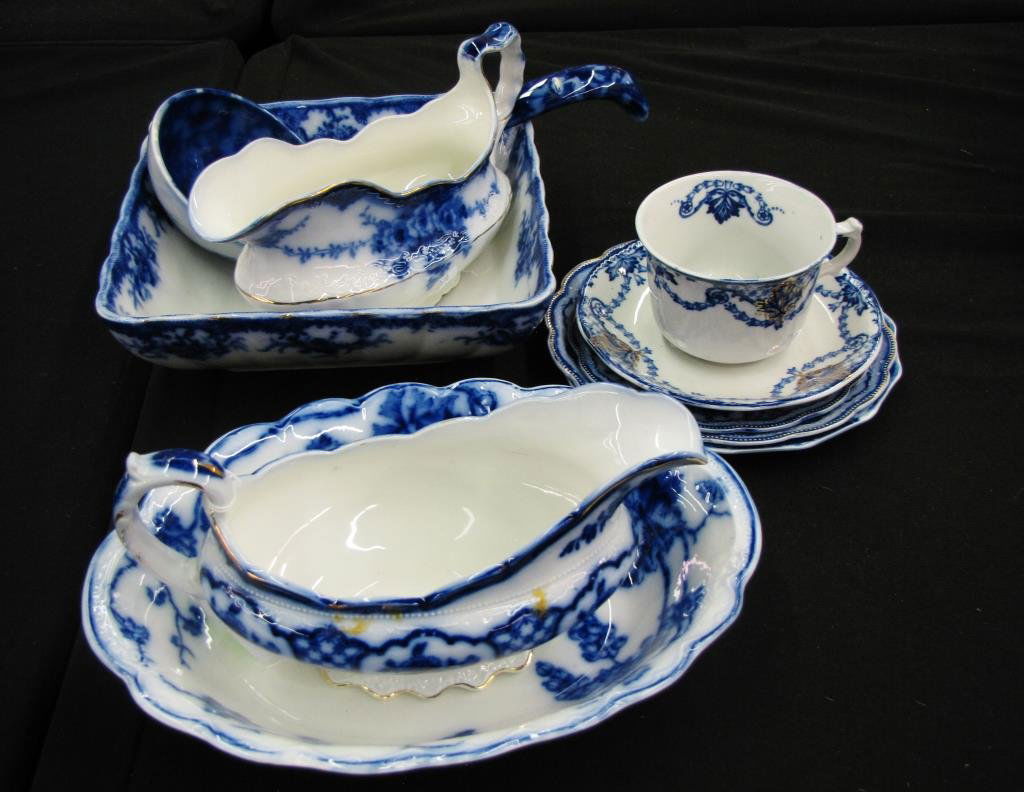 Group of Flow Blue Ironstone: A group of Flow Blue iron stone, including two gravy boats, square and oval vegetable servers, cup and saucer, three small plates, and large dipper