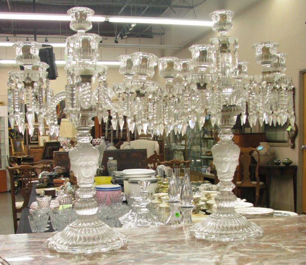 Pair of Baccarat Crystal Figural Candlesticks: A pair of Baccarat Crystal figural six branch candlesticks depicting three faces on base, 24" high, with two non-original bobeches, one candle arm broken and repaired, and one candle arm broken needin